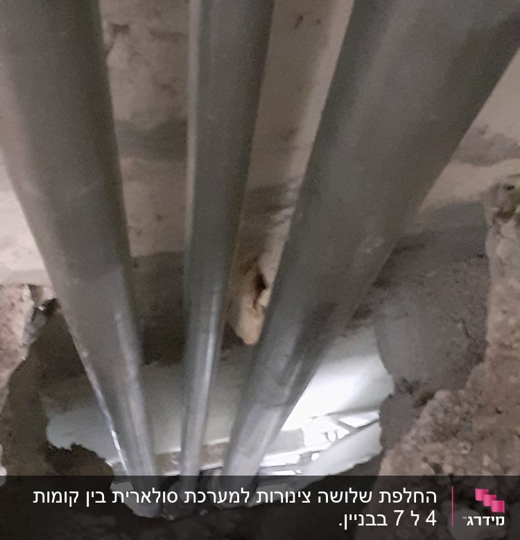 צינורות מתכת בתוך קיר עם חור בטון